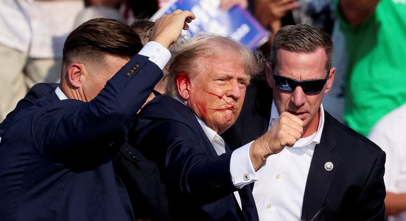 Former President Donald Trump gesturing as he is assisted by the Secret Service after he was shot during a campaign rally in Pennsylvania.REUTERS/Brendan McDermid