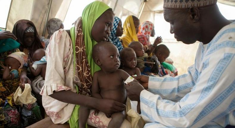 An health official measures the arm circumference of a child to control malnutrition at UNICEF Clinic near a camp for Internal displaced people (IDP) Camps in Dikwa, Nigeria February 14, 2017