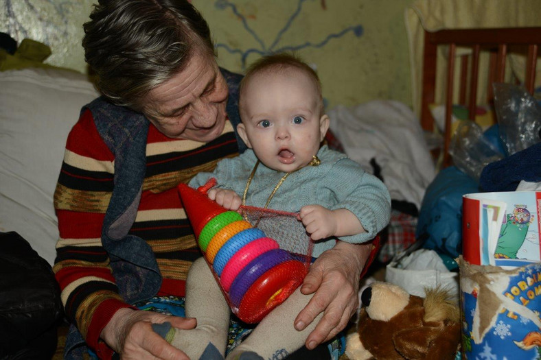 Babcia z wnuczką w schronie. Dziewczynka bawi się zabawkami od UNICEF 