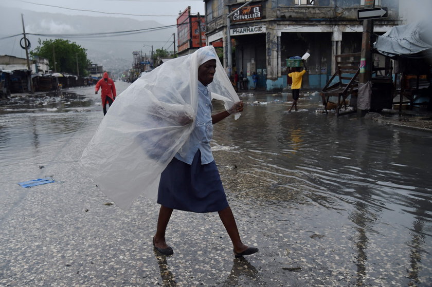 Kobieta chroni się przed deszczem w stolicy Haiti