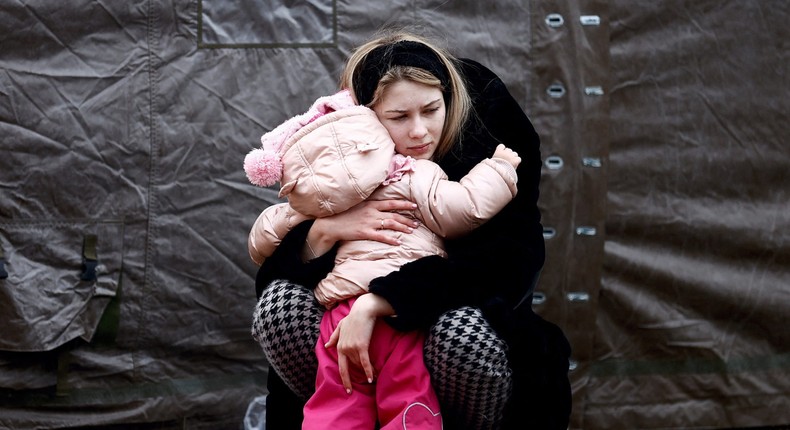 A woman fleeing Russian invasion of Ukraine hugs a child at a temporary camp in Przemysl, Poland, February 28, 2022