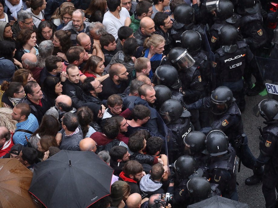 Riot police face off with demonstrators outside a polling station for the banned independence referendum in Barcelona, Spain, October 1, 2017.