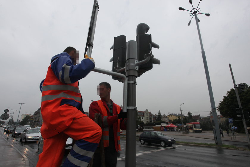 robotnicy instalują kamery przy drodze