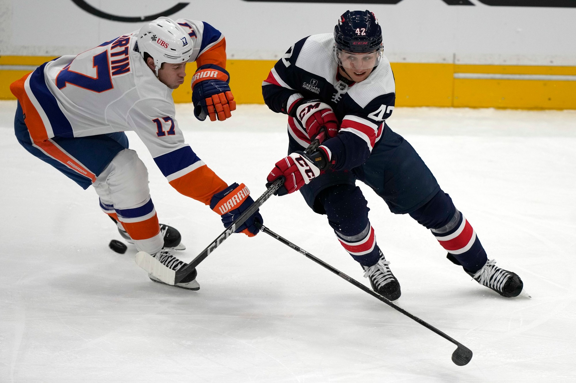Obranca Washingtonu Capitals Martin Fehérváry proti hráčovi NY Islanders Mattovi Martinovi.