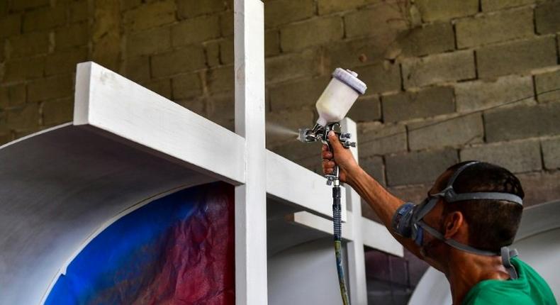 An inmate of La Joya prison in Panama works on painting a cross that will be used during Pope Francis's visit to Panama for World Youth Day celebrations in January