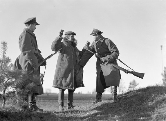 Patrol przeszukuje mężczyznę podejrzanego o przemyt (1934, CC0 1.0 Universal (CC0 1.0) Przekazanie do Domeny Publicznej).