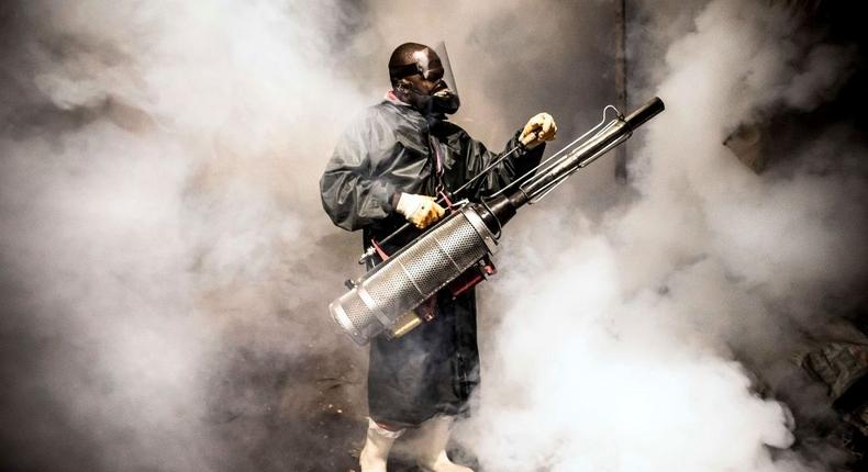 TOPSHOT - A member of a privately-funded NGO working with county officials wearing protective gear fumigates and disinfects on April 15, 2020, during the dusk-to-dawn curfew imposed by the Kenyan Government, the streets and the stalls at Parklands City Park Market in Nairobi to help curb the spread of the COVID-19 coronavirus. (Photo by LUIS TATO / AFP) (Photo by LUIS TATO/AFP via Getty Images)