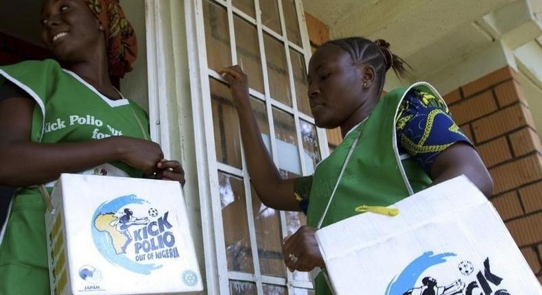 Volunteer Health officials wait to immunise children at a school in Nigeria's capital Abuja.