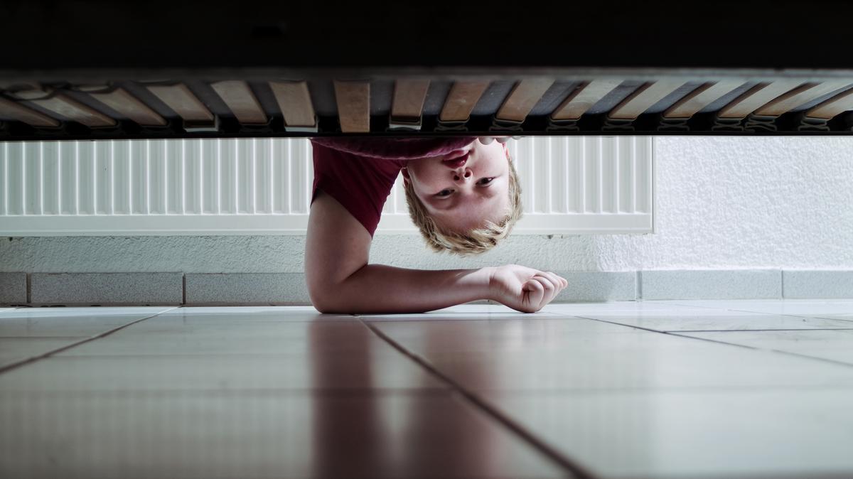 Ребенок заглядывает под кровать