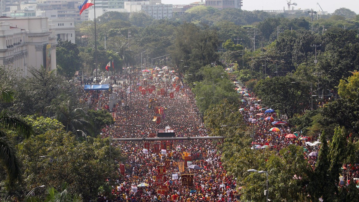 A Philippine flag flutters as devotees parade the black statue of Jesus Christ during the annual Bla