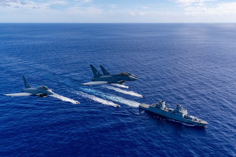 Trzy niemieckie myśliwce Eurofoghter Typhoon w czasie lotu nad fregatą typu Baden-Württemberg. Źródło: Bundeswehr