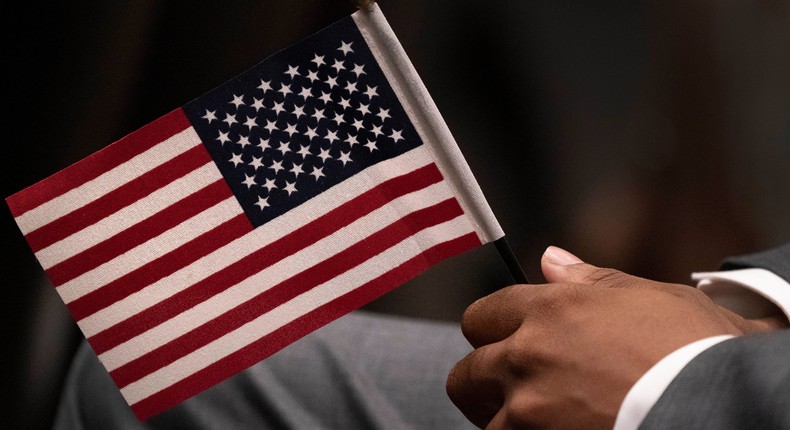 Leon Small, originally from Jamaica, holds a United States flag in a naturalization ceremony, Wednesday, April 28, 2021 in New York.AP Photo/Mark Lennihan