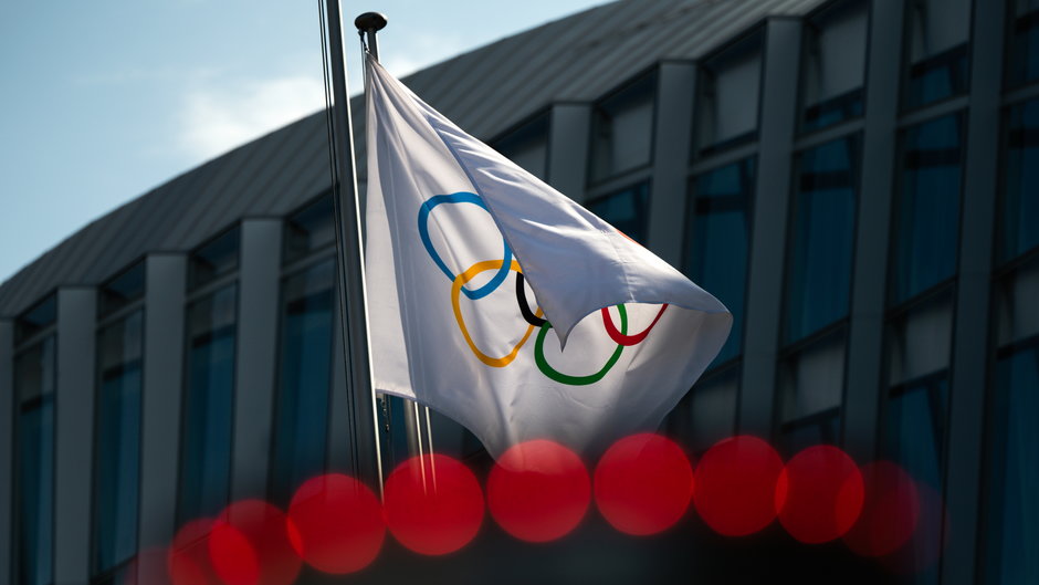 Flaga Olimpijska unosząca się obok siedziby Międzynarodowego Komitetu Olimpijskiego (MKOl) w Lozannie