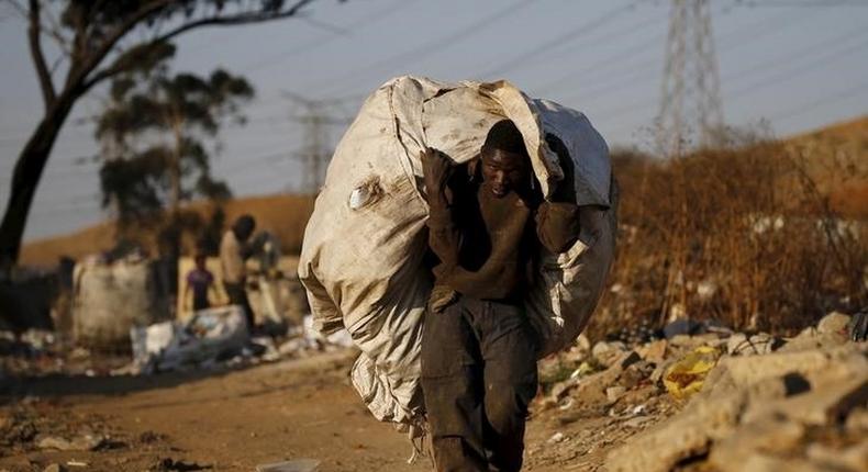 An unemployed man carries a bag full of recyclable waste material which he sells for a living, in Daveland near Soweto, South Africa August 4, 2015. REUTERS/Siphiwe Sibeko