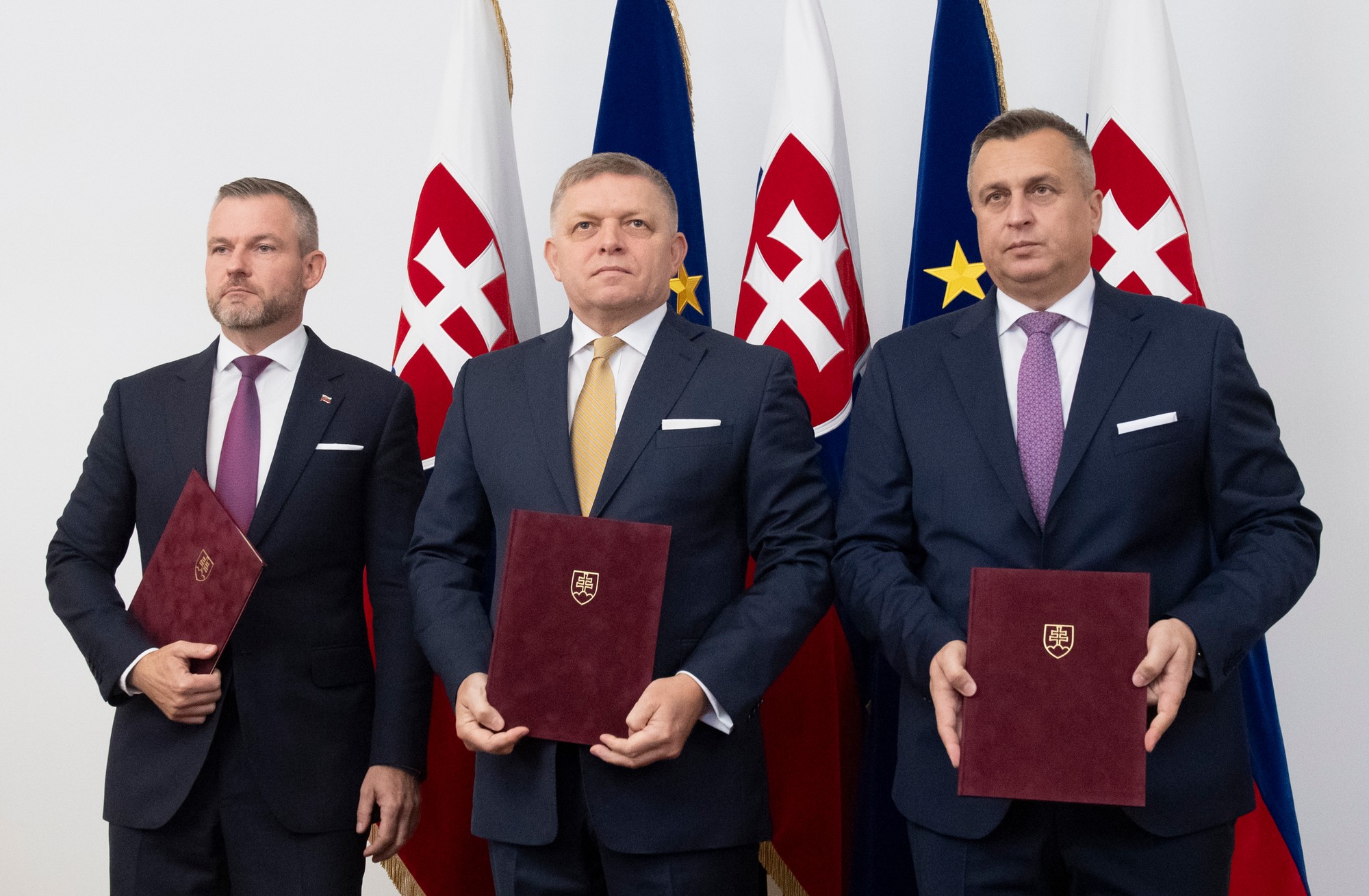 Zľava predseda strany Hlas-SD Peter Pellegrini, predseda Smer-SD Robert Fico a predseda strany SNS Andrej Danko pózujú po podpise koaličnej dohody v Bratislave.
