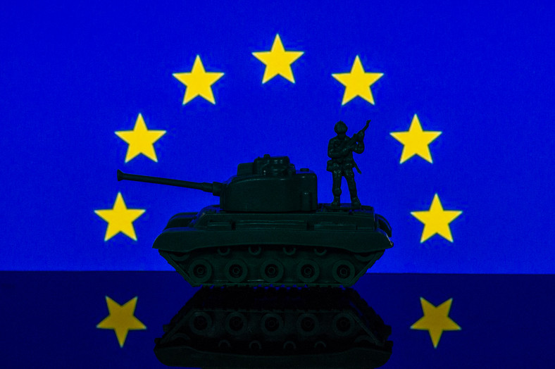 Ilustracja z postaciami żołnierza i czołgu przed europejską flagą UE