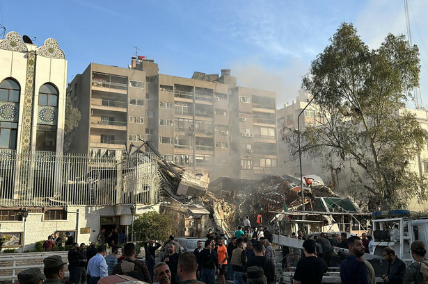 Pracownicy służb ratunkowych i bezpieczeństwa gromadzą się w okolicy budynku sąsiadującego z ambasadą Iranu w stolicy Syrii, Damaszku, 1 kwietnia 2024 r.