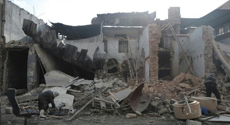 Syrian men inspect the rubble of a destroyed house in the rebel-held town of Douma, on the eastern outskirts of Damascus, on December 30, 2016