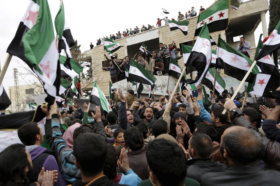 Protesters carry Free Syrian Army flags and chant slogans during an antigovernment protest in the town of Marat Numan in Idlib Province, Syria, on March 4.