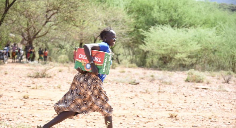 Resident of Tiaty Subcounty with the carton of beer donated (Nation) 