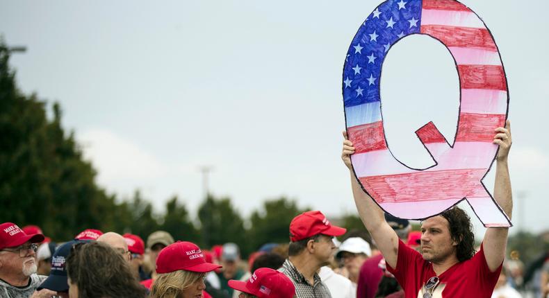 A protester holds a Q sign as he waits in line with others to enter a Trump campaign rally in Wilkes-Barre, Pennsylvania.AP Photo/Matt Rourke