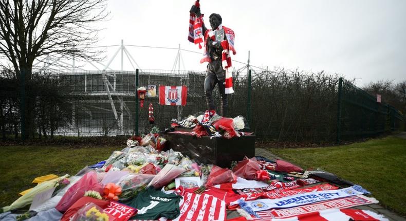 A statue of Stoke City and England's former goalkeeper Gordon Banks is draped in scarves and surrounded by floral tributes to honour England's World Cup winning goalkeeper, outside the Bet365 stadium in Stoke-on-Trent, central England