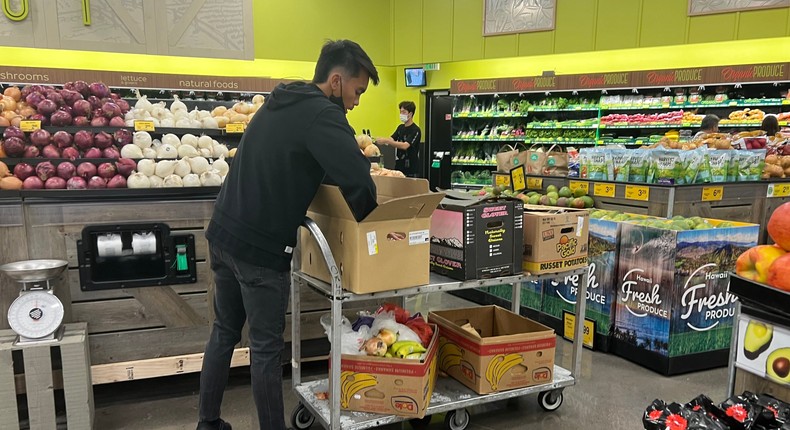 Grocery store worker stocking produce at Foodland.Morgan Pmaikai Lee/Insider