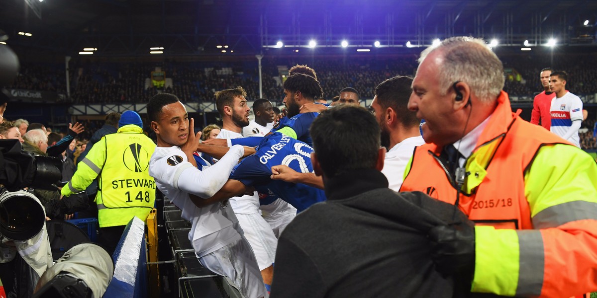 A fan carrying a toddler threw a punch during a mass brawl between Everton and Lyon players