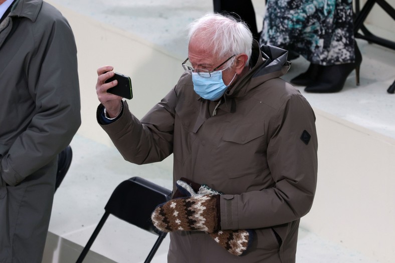 Senator Bernie Sanders, an Independent from Vermont, takes photographs with a mobile device during the 59th presidential inauguration in Washington, D.C., U.S., on Wednesday, Jan. 20, 2021. Biden will propose a broad immigration overhaul on his first day as president, including a shortened pathway to U.S. citizenship for undocumented migrants - a complete reversal from Donald Trump's immigration restrictions and crackdowns, but one that faces major roadblocks in Congress. Photographer: Tasos Katopodis/Getty Images/Bloomberg