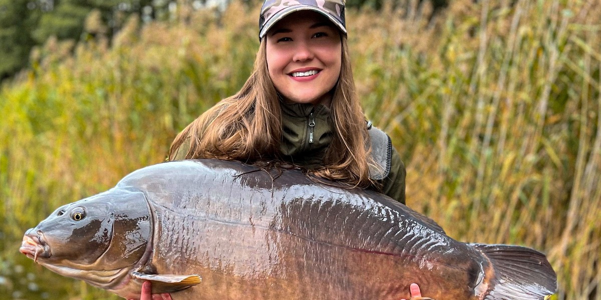 Pani Katarzyna ze złowionym przez siebie największym karpiem. Ryba wróciła do jeziora. Ważyła 29,7 kg. 