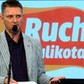 Andrzej Rozenek na tle logo Ruchu Palikota