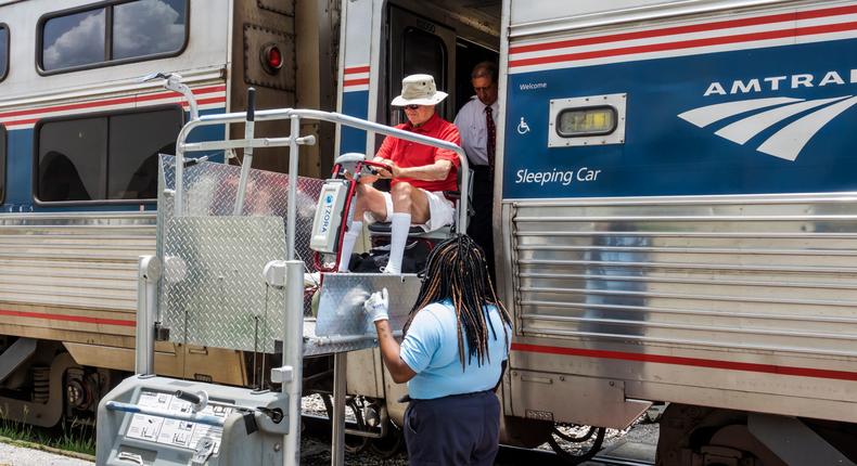 Florida, Orlando, Amtrak, passenger in wheelchair assisted boarding with crew.