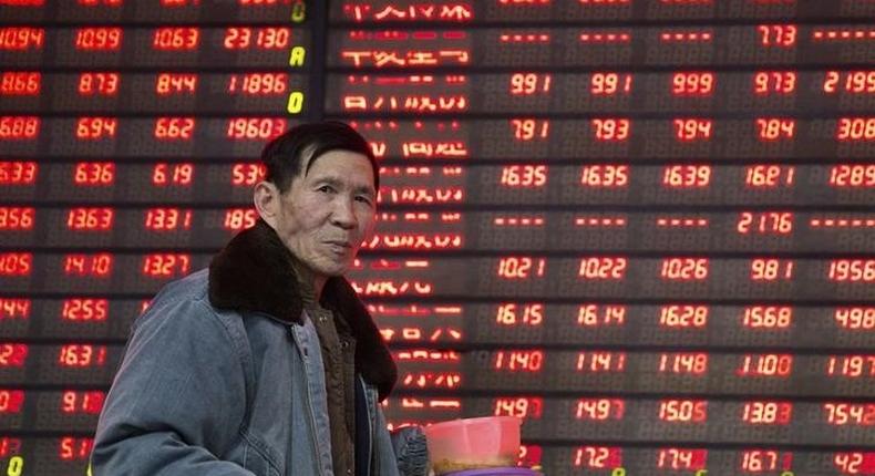 An investor walks past an electronic screen showing stock information at a brokerage house in Nanjing, Jiangsu province, China January 14, 2016. REUTERS/China Daily