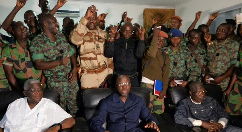 A delegation of mutinous Ivorian soldiers stand behind Defence Minister Alain-Richard Donwahi (C) as he speaks to journalists in Bouake, on January 7, 2017