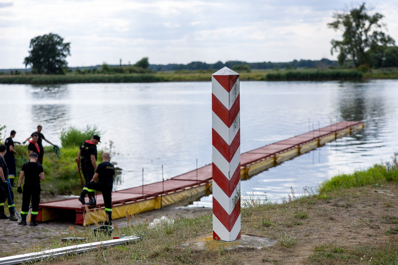 Widuchowa (woj. zachodniopomorskie), 12.08.2022. Strażacy ustawiają specjalną zaporę, której zadaniem będzie zatrzymywanie śniętych ryb płynących z nurtem Odry