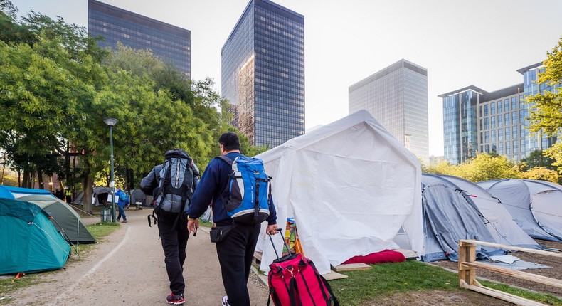 Refugees leave a tent camp for refugees in Brussels on Thursday, Oct. 1, 2015.