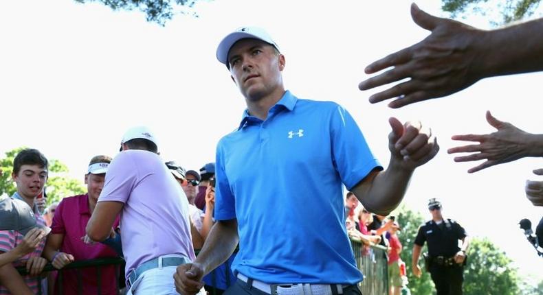 Jordan Spieth of the US high-fives fans after putting on the ninth green during the first round of the Travelers Championship, at TPC River Highlands in Cromwell, Connecticut, on June 22, 2017