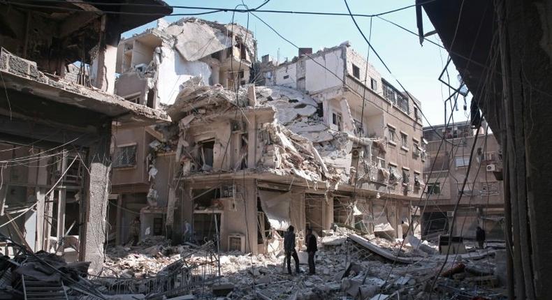 Residents search for survivors amid the rubble of a building following a reported air strike on Damascus' northeastern rebel-held al-Qaboun surburb, on February 24, 2017