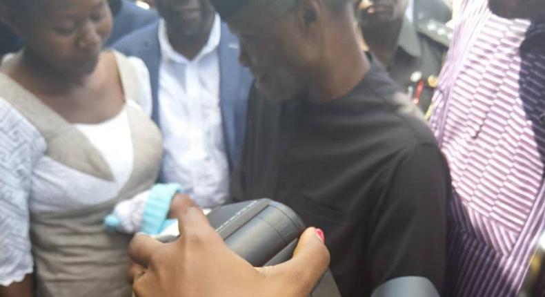 Vice President Yemi Osinbajo cradles new born given birth to in IDP camp