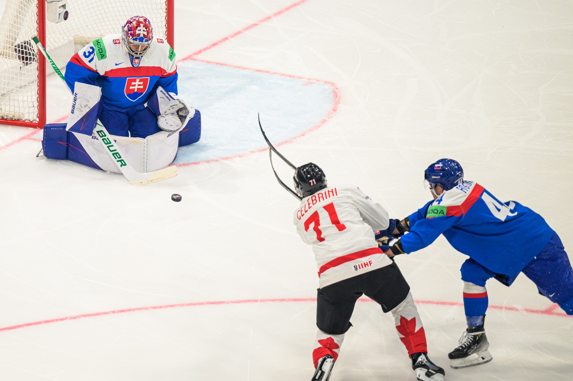 Zľava brankár Samuel Hlavaj (Slovensko), Macklin Celebrini (Kanada) a Mislav Rosandič (Slovensko). 