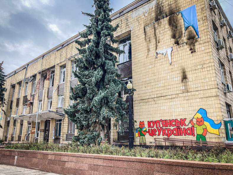 Zniszczony budynek z napisem: Kupiańsk jest ukraiński