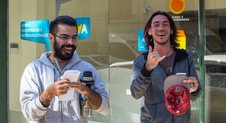 Two men express joy after registering as marijuana's buyers in Montevideo