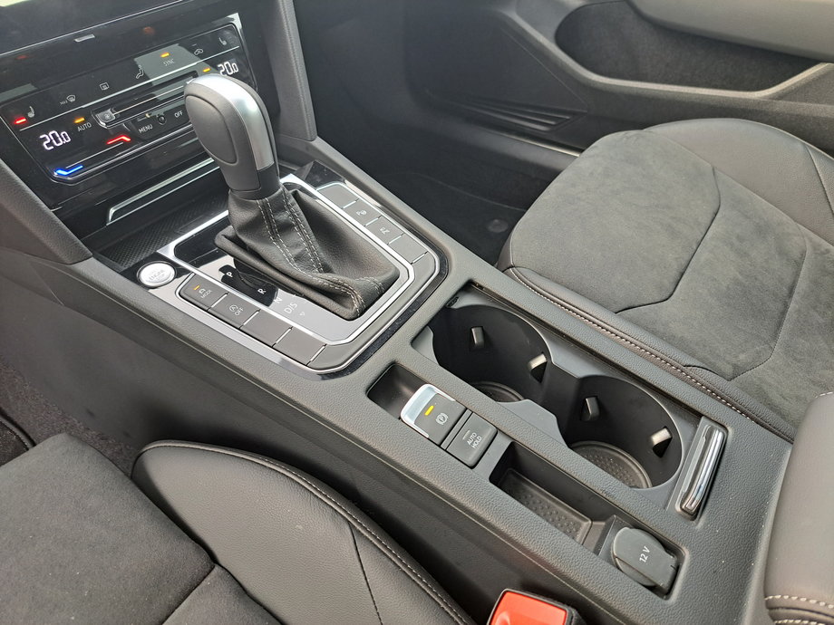 Volkswagen Arteon - między fotelami jest miejsce na kubki, mamy też półkę na smartfona oraz gniazda do jego ładowania.