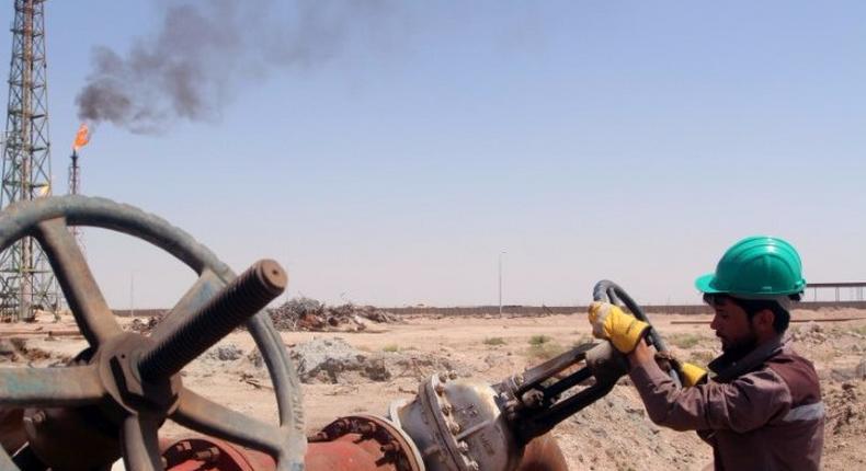 A worker checks the valve of an oil pipe at Al-Sheiba oil refinery in the southern Iraq city of Basra