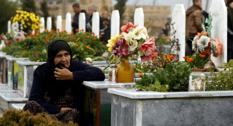 A woman in the northeastern Syrian town of Qamishli visits a grave during the February 2019 funeral of a fighter from the Kurdish-led YPJ. The Syrian Kurdish administration is seeking an international tribunal to try members of the Islamic State group