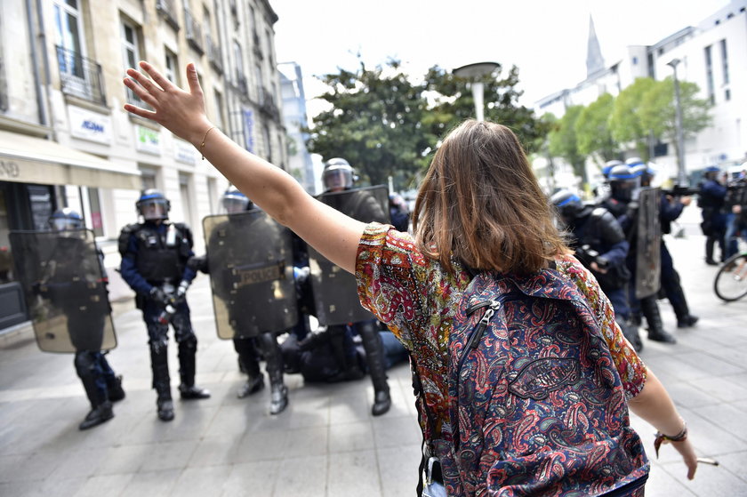 Protestująca kobieta w Paryżu próbuje zatrzymać oddział policji