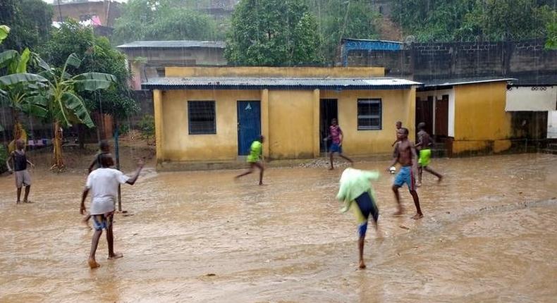 Youths play soccer in the rain at the Ndako ya Biso (Our House) refugee centre for street children in the Democratic Republic of Congo's capital Kinshasa, February 5, 2016. Picture taken February 5, 2016. REUTERS/Aaron Ross