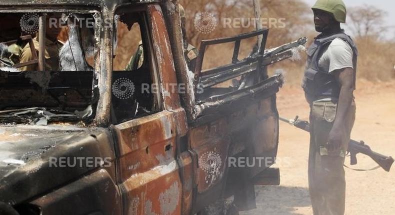 Security officers guard a police car, which was burnt during an attack on a convoy escorting Mandera governor Ali Roba, outside Mandera town, near Kenya's border with Somalia and Ethiopia, March 13, 2015.   REUTERS/Stringer