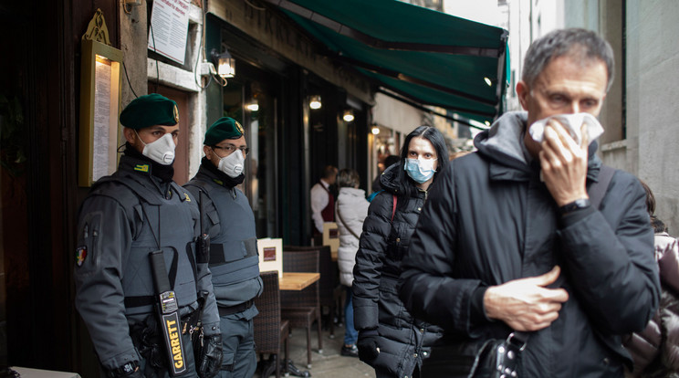 A koronavírus elleni védekezésül szájmaszkot viselő rendőrök és turisták a velencei karneválon a Szent Márk tér közelében 2020. február 23-án. Luca Zaia, az északkelet-olaszországi Veneto tartomány kormányzója ezen a napon bejelentette, hogy a koronavírus-járvány olaszországi terjedése miatt megszakítják a velencei karnevált. A tüdőgyulladást okozó, Covid-19-nek elnevezett újfajta koronavírus fertőzöttjeinek száma 115 fölé emelkedett Olaszországban / Fotó: MTI/EPA/Abir Szultan