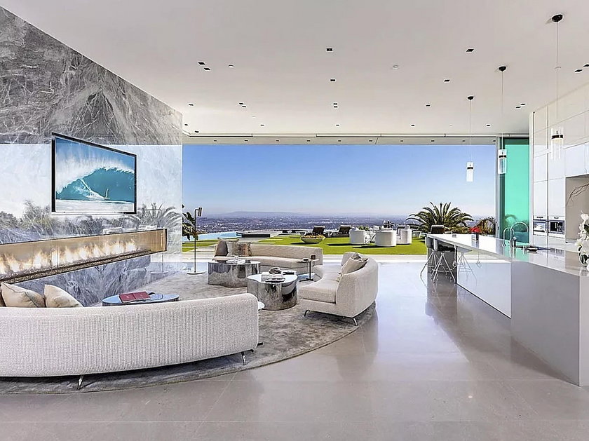 LeBron James kupił willę w Hollywood za 52 mlns then cross the floating bridge to breathtaking living and dining rooms with massive marble fireplaces. Floor-to-ceiling glass walls provide explosive views